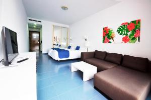 - un salon avec un canapé et un lit dans l'établissement Vistaflor Cura Marina, à Playa del Cura
