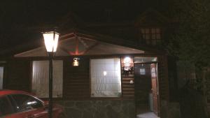 uma casa à noite com uma luz de rua e um carro em Departamentos Ahnen em Ushuaia