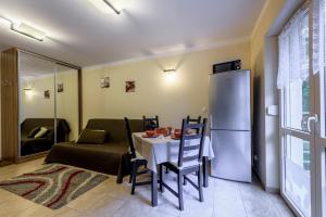 a kitchen and dining room with a table and a refrigerator at Apartament Kawowy - 5D Apartamenty in Świeradów-Zdrój