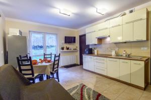 a kitchen and dining room with a table and a dining room at Apartament Kawowy - 5D Apartamenty in Świeradów-Zdrój