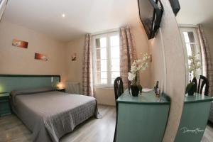 a bedroom with a bed and a tv on a wall at hotel des 2 nations in Luchon