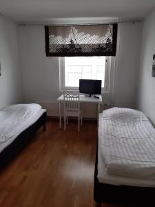um quarto com 2 camas e uma secretária com uma televisão em Apartment Asemakatu 20 em Kuopio