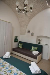 - un salon avec un canapé et un lit dans l'établissement Trulli Dal Sole alla Luna, à Martina Franca