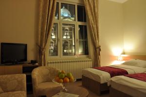 um quarto de hotel com duas camas e uma mesa com uma tigela de fruta em Apartments Legacy em Belgrado