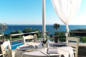 a dining table with a view of the ocean at Acrotel Elea Beach in Elia