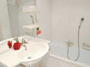 ein weißes Bad mit einem Waschbecken und einer Dusche in der Unterkunft Hotel Donatello in Padua