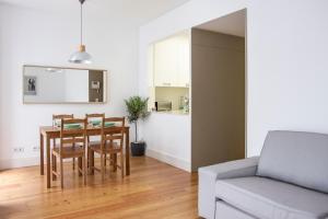 a kitchen and dining room with a table and a couch at Principe Real Apartment in Lisbon