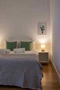 a bedroom with a large bed with green pillows at Principe Real Apartment in Lisbon