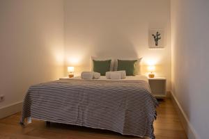 a bedroom with a large bed with green pillows at Principe Real Apartment in Lisbon