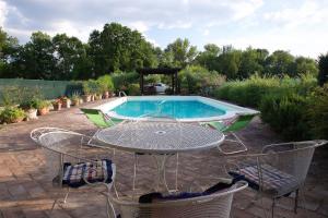 a table and chairs in front of a pool at Al Guado di Assisi B&B in Bastia Umbra