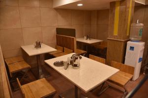 um restaurante com mesas e cadeiras e um refrigerador de água em Sivamurugan Hotels em Kumbakonam