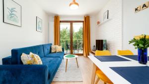- un salon avec un canapé bleu et une table dans l'établissement Apartamenty EverySky - Ogrodnicza 7-9, à Karpacz