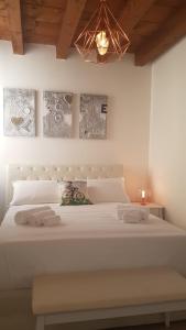 een slaapkamer met een groot wit bed en een kroonluchter bij Palazzo Ponte Pietra in Verona