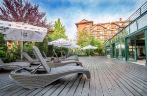a group of chairs and umbrellas on a deck at Caro Hotel in Bucharest