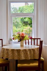 einen Tisch mit einer Blumenvase vor einem Fenster in der Unterkunft Caliburn in Alyth