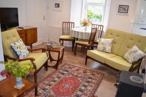 a living room with chairs and a table with a television at Caliburn in Alyth