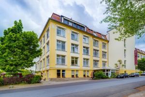 a yellow building on the side of a street at Hotel Alte Klavierfabrik Meißen in Meißen