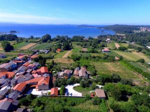 - une vue aérienne sur un village avec des maisons et l'eau dans l'établissement Hotel Rústico Casa do Prado, à Boiro