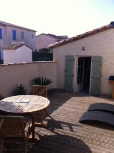 eine Terrasse mit einem Tisch und Stühlen sowie ein Gebäude in der Unterkunft La Paloma in Aigues-Mortes