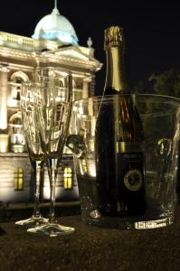 una bottiglia di champagne e due bicchieri su un tavolo di Apartments Legacy a Belgrado