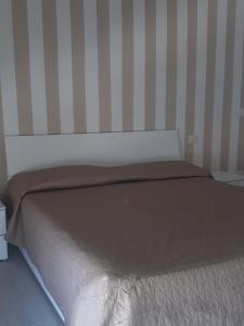 a bed with a brown blanket on top of it at casanelmare in Mola di Bari
