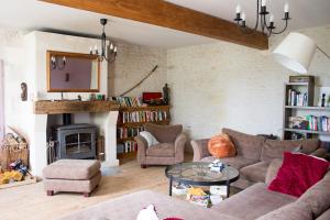 a living room with a couch and chairs and a fireplace at Le Charhido in Saint-Fort-sur-Gironde