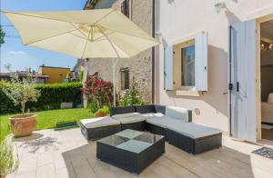 um pátio com um sofá e um guarda-chuva em Sweet Corner em Castelnuovo del Garda