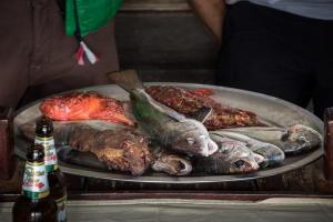 a plate of fish on a table with a bottle of beer at Adriatrek Bed & Breakfast in Petrovac na Moru +37 photos