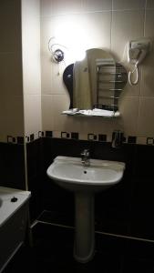 y baño con lavabo blanco y espejo. en Hotel Ararat, en Lermontov