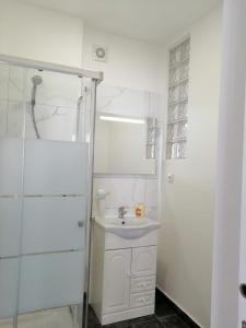 un bagno bianco con lavandino e doccia di Casa do canto a Tavira Altre 9 foto