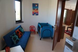 a living room with a blue couch and a red chair at Apartments Paskalina in Byala