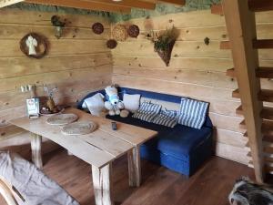 a living room with a blue couch and a table at Domki nad Sanem in Lesko +38 photos