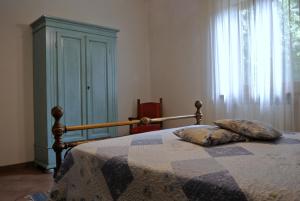 a bedroom with a bed with a blanket and a window at Lovely Tuscan Country House in Siena
