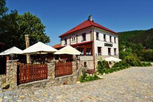 un bâtiment avec une clôture et des parasols devant lui dans l'établissement Penzion Karlštejn, à Karlštejn