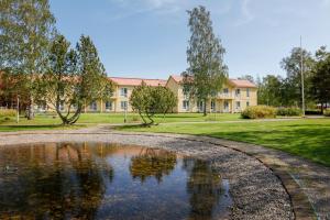 a house with a pond in front of it at Hotel Norrvalla in Vöyri