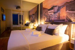 a bedroom with a large white bed with a large mirror at Apartment Edgar in Makarska