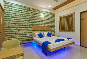 a bedroom with a bed and a brick wall at Hotel Ganeshratna Executive Kolhapur in Kolhapur