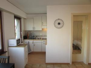 a kitchen with white cabinets and a microwave at Studio à Sion in Sion