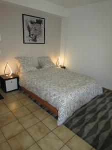 a bedroom with a bed with two lamps on it at Studio à Sion in Sion