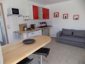 a kitchen with a wooden table and a couch at Villa VAYA in Villemoustaussou