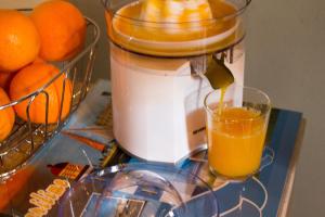 a blender filled with orange juice next to a basket of oranges at Le Charhido in Saint-Fort-sur-Gironde