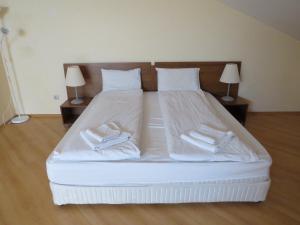 a large bed with white sheets and towels on it at Villa Park Studio Apartment nr 409 in Borovets