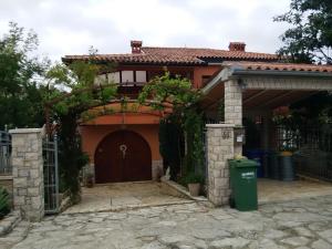ein Haus mit einem Tor und einer Garage in der Unterkunft Apartments villa MaVeRo in Banjole