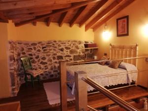 Un dormitorio con una cama y una pared de piedra. en Apartamentos Rurales A Torre, en Santa María