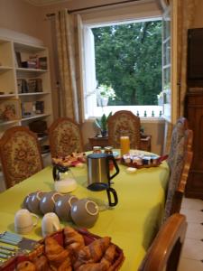a dining room table with a yellow table cloth at LE CHEMINARD in Feugarolles