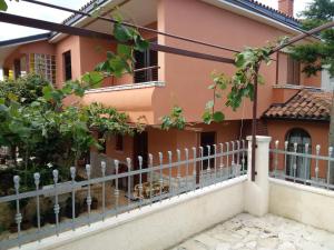a pink house with a fence at Apartments villa MaVeRo in Banjole