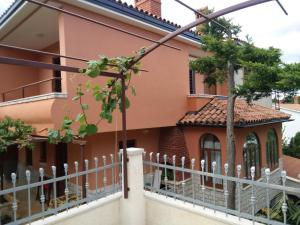 a house with a fence in front of it at Apartments villa MaVeRo in Banjole