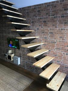 d'un mur en briques avec des escaliers en bois et d'une télévision. dans l'établissement AL Belém 85, à Lisbonne