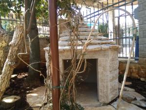 a stone fireplace in a yard with a tree at Apartments villa MaVeRo in Banjole
