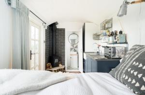 a bedroom with a white bed and a kitchen at Purbeck Shepherd Huts in Worth Matravers